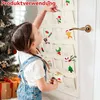 A young girl is reaching into a fabric advent calendar hanging on a door, next to a Christmas tree. Produktbild-Vorschau