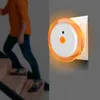 A person is walking up stairs, with a night light plugged into the wall. Produktbild-Vorschau