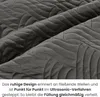Close-up of a quilted fabric with a wave-like pattern. Náhled obrázku produktu