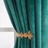 A close-up of a green velvet curtain held back by a gold leaf-shaped tie-back. Produktbild-Vorschau