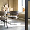 A dining room scene with chairs around a table, featuring decorative vases and natural light. Produktbild-Vorschau