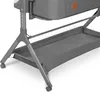 Close-up view of the lower part of a baby crib, showing the frame, storage tray, and wheels. Produktbild-Vorschau