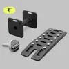 A set of adjustable dumbbells and accessories against a plain background. Produktbild-Vorschau