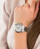 A close-up shot of a woman's wrist wearing a silver watch. Produktbild-Vorschau