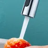 Water is running from a faucet onto an orange object, possibly a fruit or vegetable, being held by a hand. Anteprima dell’immagine prodotto