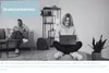 A woman is sitting on the floor with a laptop, and a man is sitting on a couch in the background. Produktbild-Vorschau