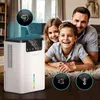 A family is lying on the floor with a dehumidifier in the foreground. Produktbild-Vorschau