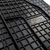 A close-up view of a black rubber car mat with a grid pattern. Produktbild-Vorschau