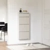 A shoe cabinet with four flip-down doors is mounted on a white wall in a hallway. A small potted plant and two books sit on top of the cabinet. A rug with slippers on it is on the floor in front of the cabinet. Voir les images du produit