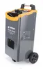 A gray and yellow battery charger with black wheels and handle, shown from a slight diagonal angle on a white background. Produktbild-Vorschau