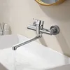 A stainless steel kitchen faucet mounted on a wall over a white sink, with water running from the spout. Podgląd zdjęcia produktu