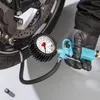 A person wearing black gloves is using a blue tire pressure gauge to check the air pressure in a motorcycle tire. Náhľad obrázku produktu
