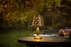 A solar-powered table lamp is placed on a wooden table outdoors, with a blurred background of trees and foliage. Anteprima dell’immagine prodotto