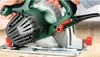 A close-up shot of a person using a Bosch circular saw on a wooden surface. Podgląd zdjęcia produktu