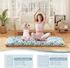 A woman and a child are meditating on a floor mat in a living room. Náhled obrázku produktu