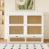 A white cabinet bed with rattan fronts is shown in a room with a painting above it and a rug in front. Podgląd zdjęcia produktu