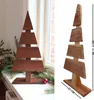 A wooden Christmas tree decoration is displayed on a windowsill next to a window, with some greenery and a red ornament. Anteprima dell’immagine prodotto