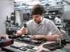 A man is working on a laptop in a workshop. Voir les images du produit