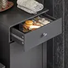 A close-up view of an open drawer in a gray cabinet, revealing bathroom accessories organized in a clear plastic divider. Anteprima dell’immagine prodotto