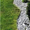 A close-up view of a garden border separating a lawn from a gravel path, with a solar-powered garden light visible. Produktbild-Vorschau