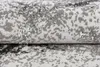 A close-up view of a rolled-up rug with a textured, abstract pattern in shades of gray and white. Anteprima dell’immagine prodotto