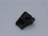 A black plastic part with a spring mechanism, likely a component for a power tool, is shown against a plain light gray background. Voir les images du produit