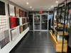 A retail store interior with acoustic wall panels displayed on a wall and shelving units with products. Produktbild-Vorschau