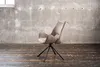A single chair is placed in a room with a concrete wall and wooden floor. Produktbild-Vorschau