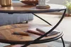 A close-up view of a two-tiered coffee table made of wood and metal, with a pen and notebooks on the lower shelf. Produktbild-Vorschau