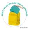 A hand is placing a turquoise Squishmallows game into a yellow backpack. Náhľad obrázku produktu