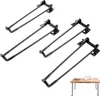 Four black metal table legs are arranged diagonally on a white background, with a small wooden table with a laptop and a book in the bottom right corner. Produktbild-Vorschau