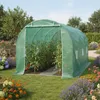 A green polyethylene greenhouse filled with tomato plants, set in a garden with flowers and a wooden bench. Podgląd zdjęcia produktu