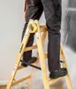 A person standing on a wooden ladder, with a roll of tape attached to the ladder. Produktbild-Vorschau