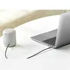 A small gray speaker is connected to a laptop via a black cable on a white table. Anteprima dell’immagine prodotto