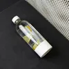 A clear glass bottle with lemon slices and a white lid and base, lying on a black surface. Voir les images du produit