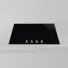 A black glass induction hob with four control knobs is shown on a light gray countertop. Produktbild-Vorschau