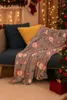 A cozy Christmas scene with a blanket draped over a couch, next to a Christmas tree. Náhled obrázku produktu