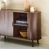 A wooden sideboard with sliding doors, decorated with vases and a basket. Anteprima dell’immagine prodotto