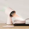 A pink mini range hood is shown directing airflow towards a steaming pot on a black induction cooktop. Náhľad obrázku produktu