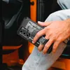 A person holding a phone case while sitting in a car. Produktbild-Vorschau