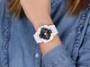 A person wearing a white Casio G-Shock watch on their wrist, with a denim shirt in the background. Produktbild-Vorschau