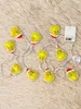 A string of Grinch-themed LED lights laid out on a fuzzy, light brown surface. Produktbild-Vorschau