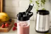 A close-up of a smoothie in a travel cup with a blender base in the background. Náhled obrázku produktu