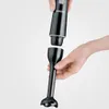 Two hands are shown detaching the blending attachment from the motor unit of a black immersion blender. Náhled obrázku produktu