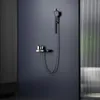 A modern shower fixture with a hand shower, thermostat, and glass shelf mounted on a dark gray wall. Náhľad obrázku produktu