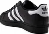A side view of a black Adidas Superstar sneaker with white stripes and heel detailing. Podgląd zdjęcia produktu