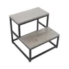 A two-step stool with a gray wood-grain finish and black metal frame, shown against a white background. Náhled obrázku produktu