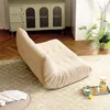 A beige sofa is placed on a rug in a living room, with a tray of drinks and fruit on the floor nearby. Produktbild-Vorschau