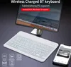 A white wireless keyboard is placed in front of a tablet displaying a beach scene. A smartphone is also visible to the right. Náhled obrázku produktu