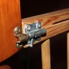 A close-up view of a wooden baby gate latch mechanism. Voir les images du produit